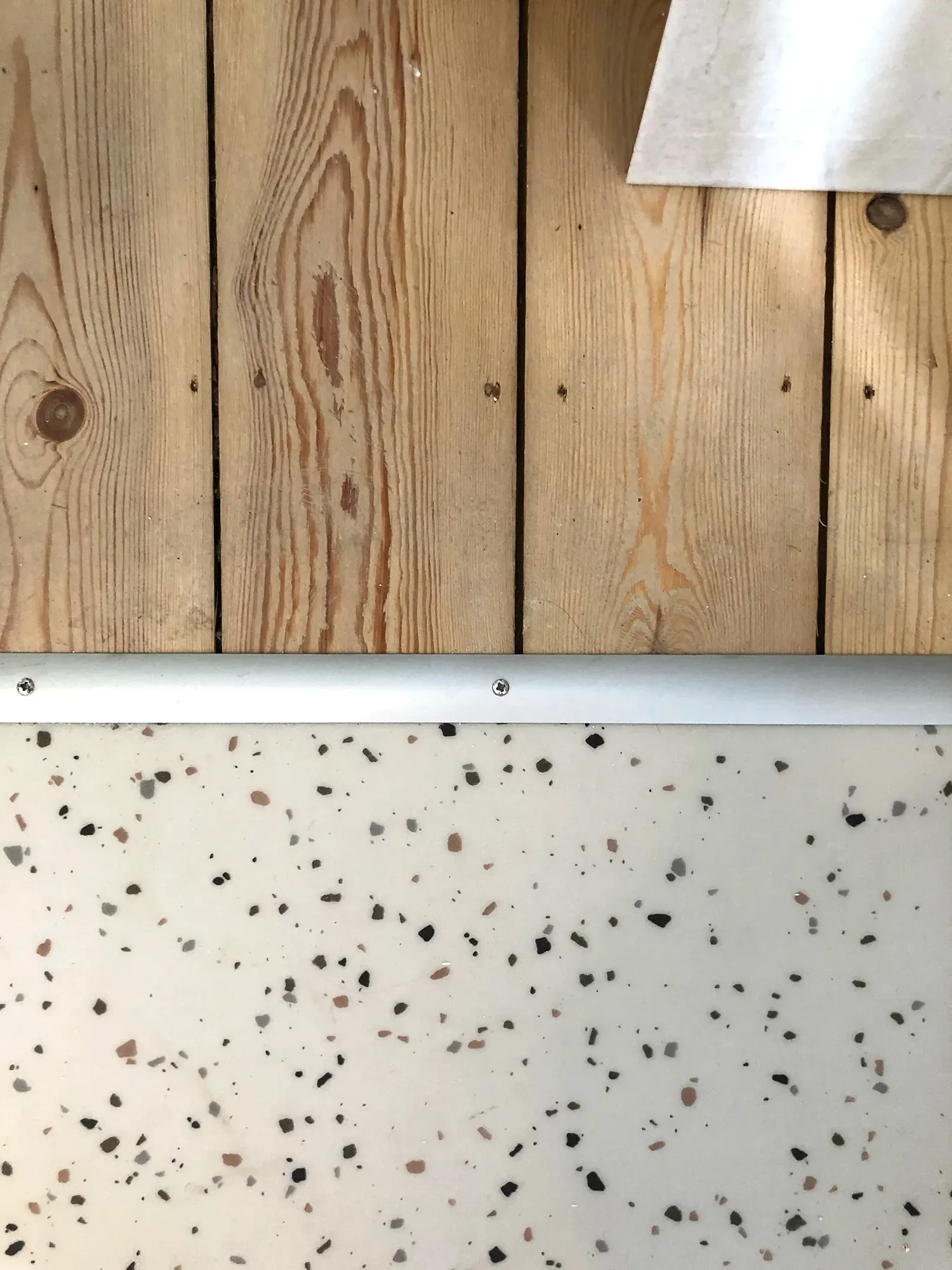 La Chasse — raccord entre parquet et surface mouchetée, détail