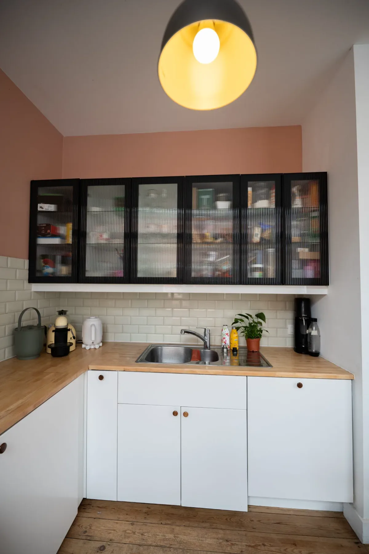 Laeken — cuisine rose poudré et meubles noirs vitrés