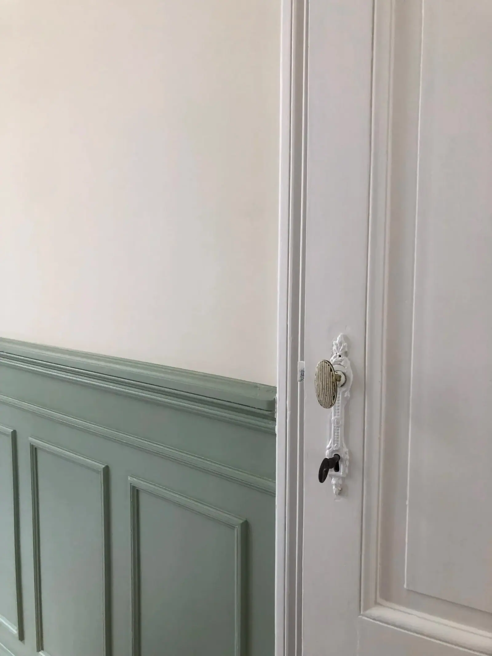 Rue de Portugal — lambris vert d'eau et poignée de porte en porcelaine, détail